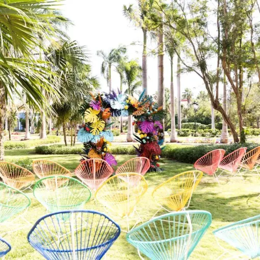 Garden wedding ceremony with colorful chairs and floral arch at Iberostar Paraiso Maya, Riviera Maya