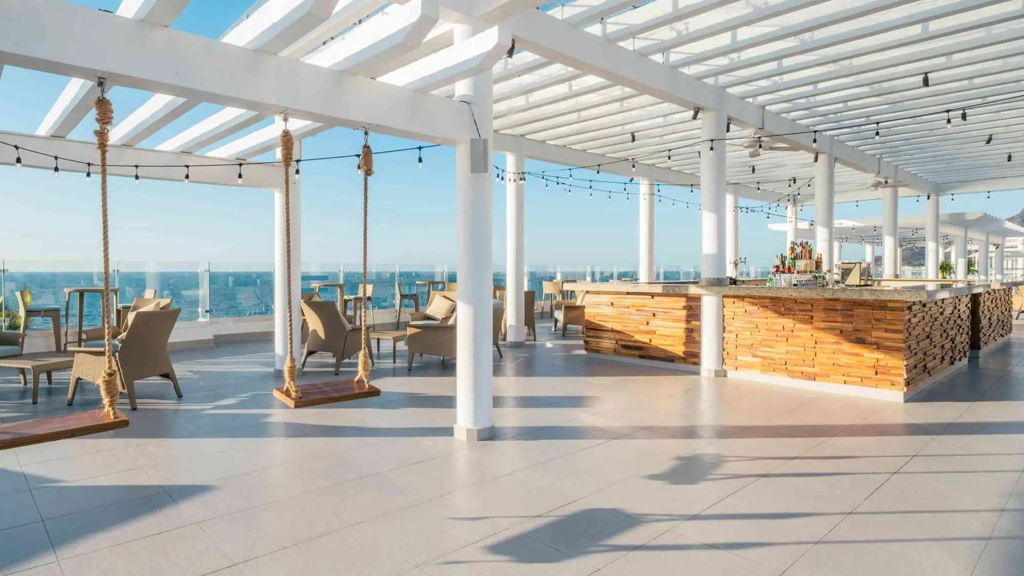 Rooftop bar with wooden swings under a white pergola at Iberostar Selection Playa Mita, Puerto Vallarta