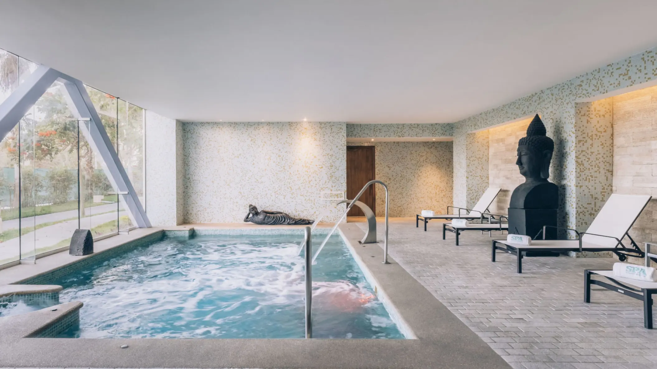 Indoor spa pool and lounge area with a Buddha statue at Iberostar Selection Playa Mita, Puerto Vallarta