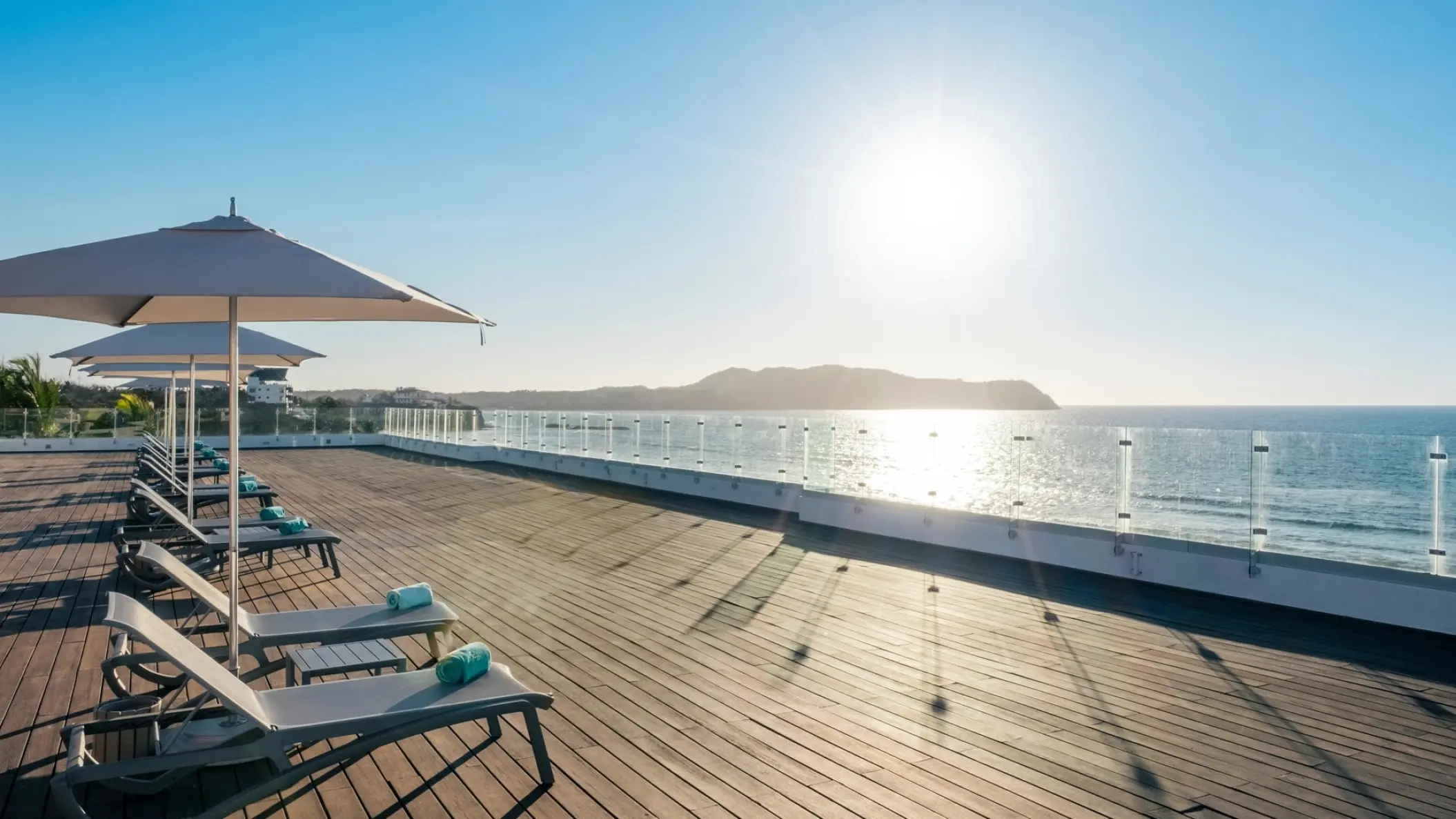 Oceanfront terrace with lounge chairs and umbrellas at Iberostar Selection Playa Mita, Puerto Vallarta