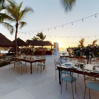 Poolside wedding reception tables with string lights and floral arrangements at Iberostar Selection Playa Mita, Puerto Vallarta