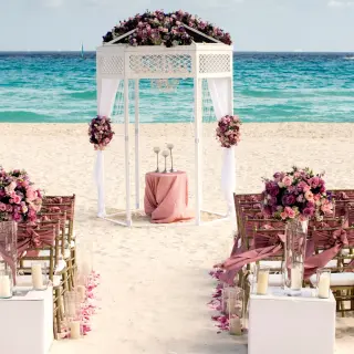 Beachfront wedding ceremony with a white gazebo and purple floral arrangements at Iberostar Waves Tucan, Playa Del Carmen