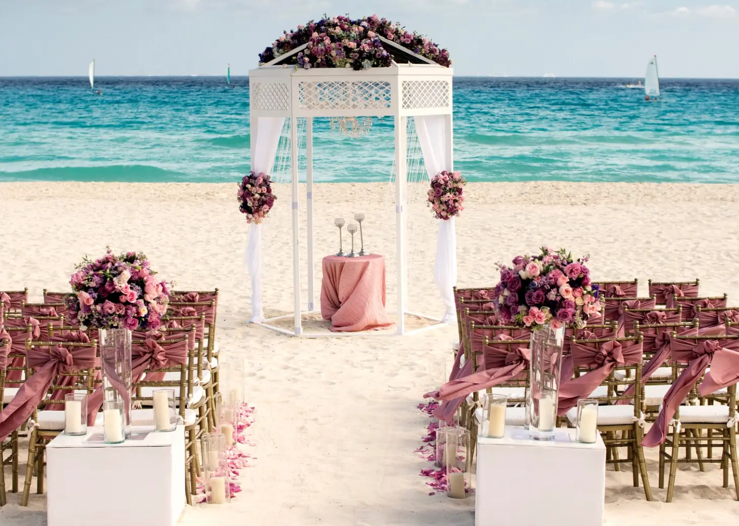 Beachfront wedding ceremony with a white gazebo and purple floral arrangements at Iberostar Waves Tucan, Playa Del Carmen
