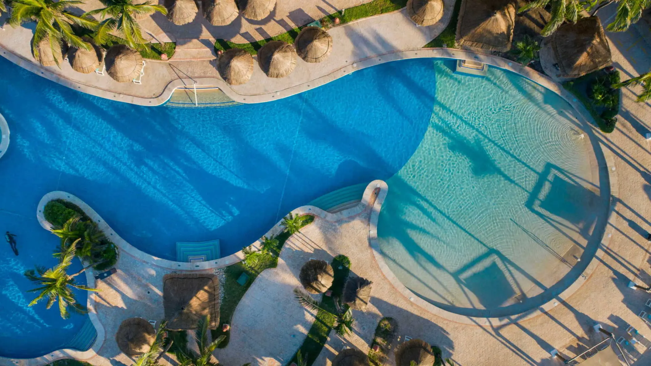 Aerial view of the winding swimming pool and palapas at Iberostar Waves Tucan, Playa Del Carmen