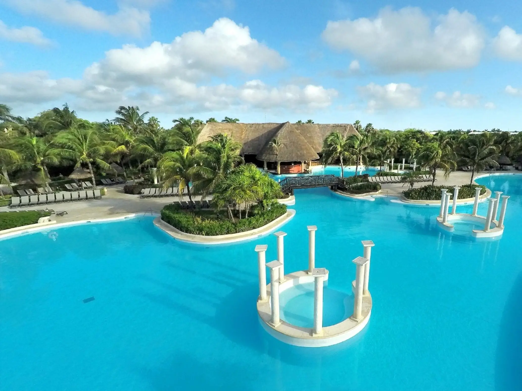 Grand Palladium Colonial swimming pool with decorative white columns and palapa roofs, Riviera Maya