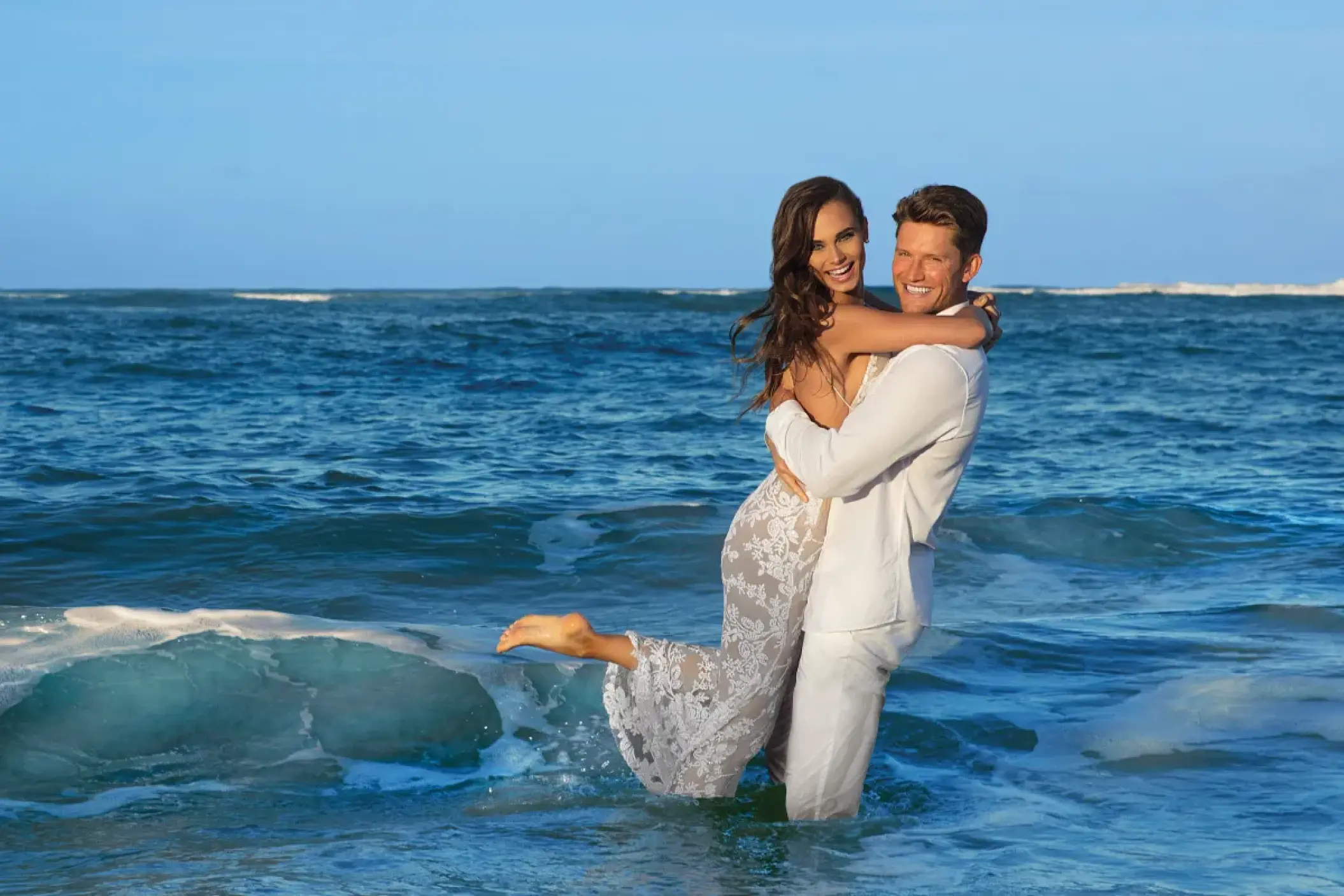 Groom lifting bride in the ocean at Dreams Onyx, Punta Cana