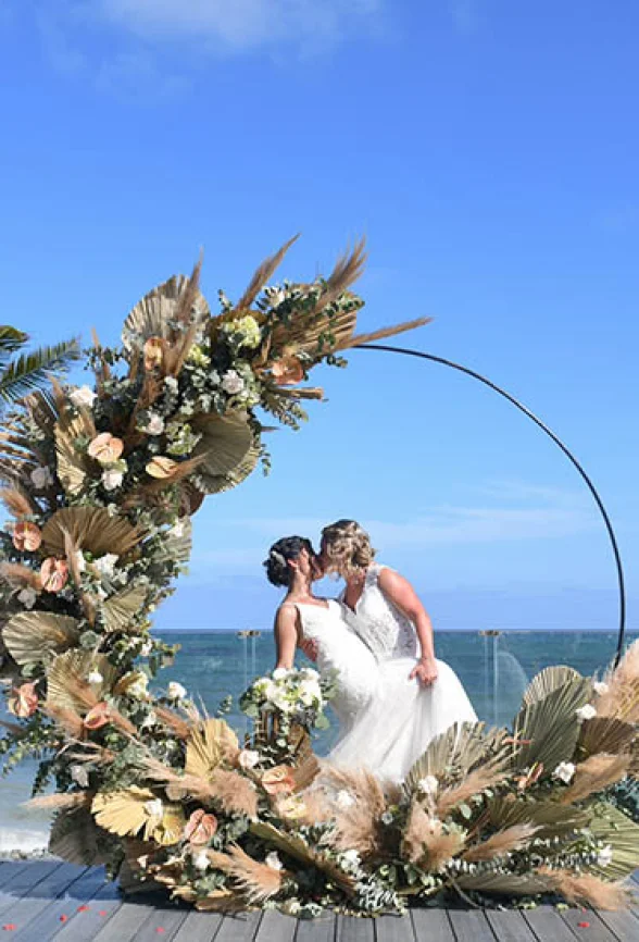 two newlywed brides kiss on a beautiful isle on the beach