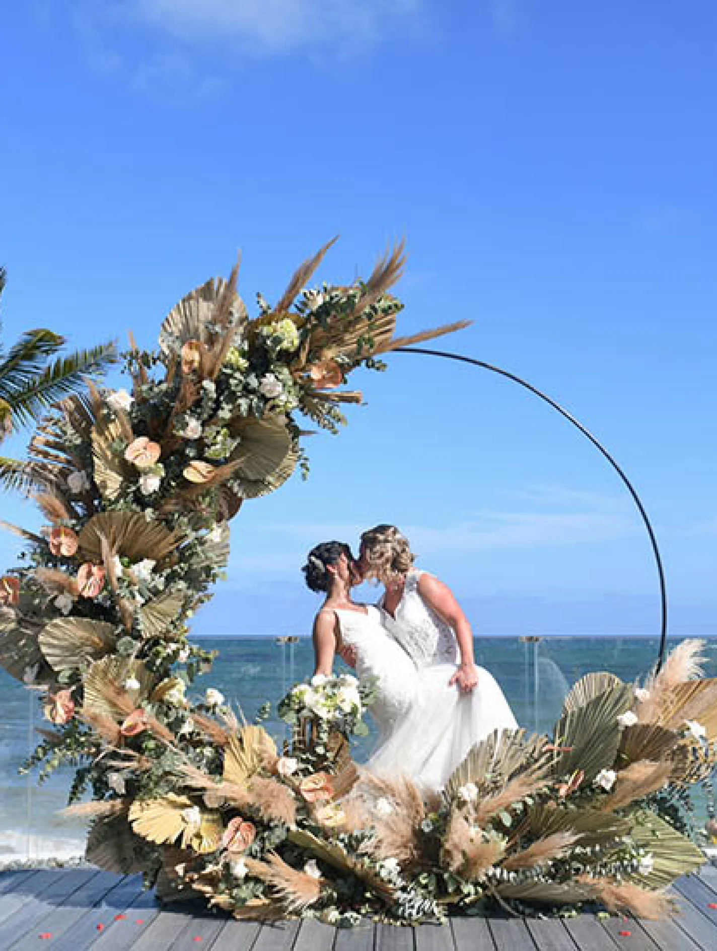 two newlywed brides kiss on a beautiful isle on the beach