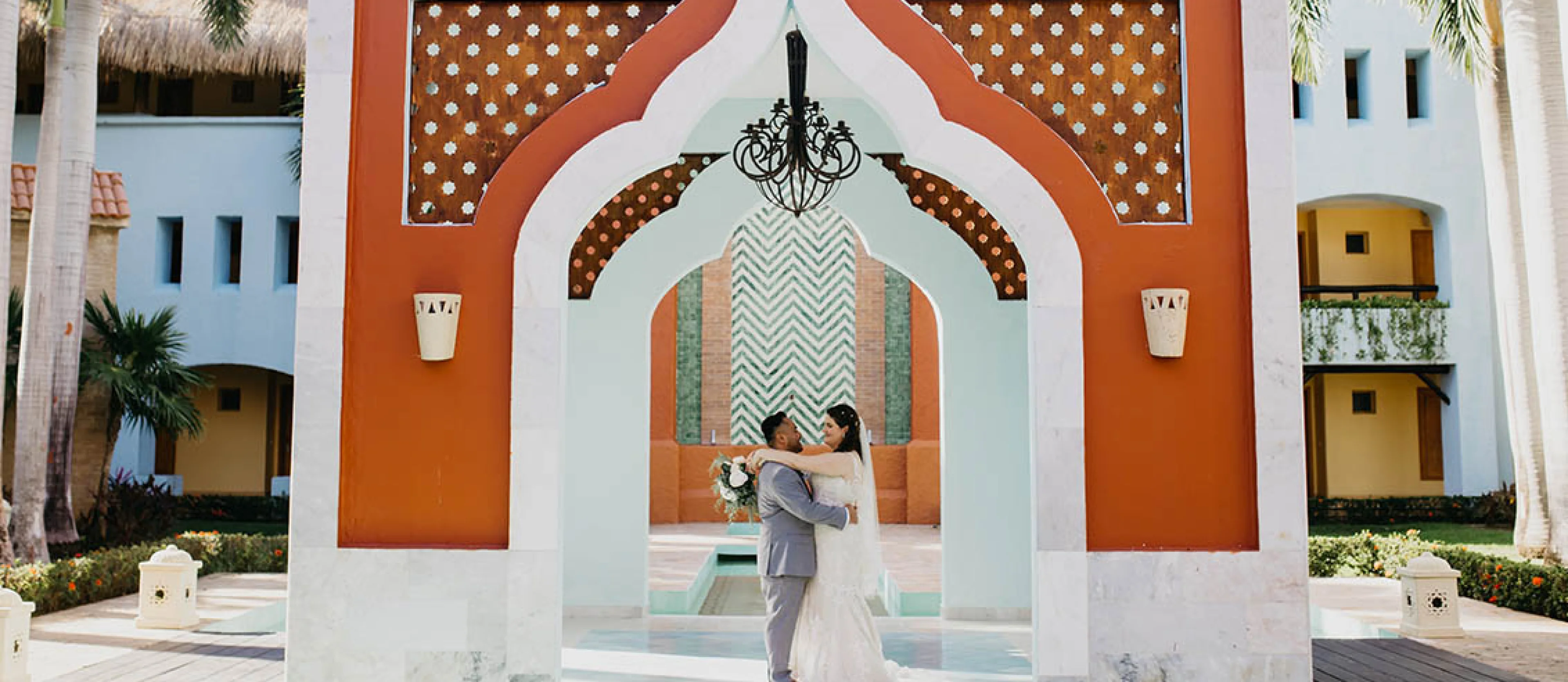 bride and groom underneath a beatiful mediterranean style arch