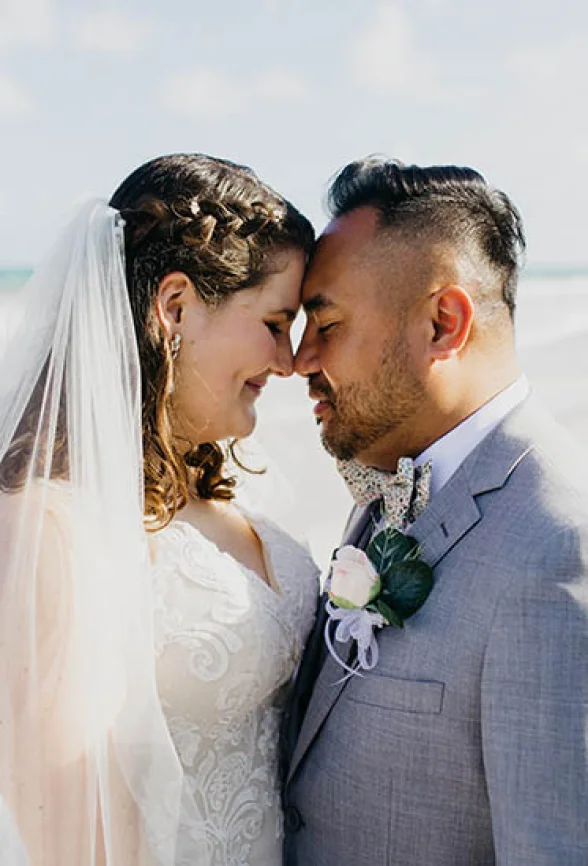 bride and groom looking at each other on the beach