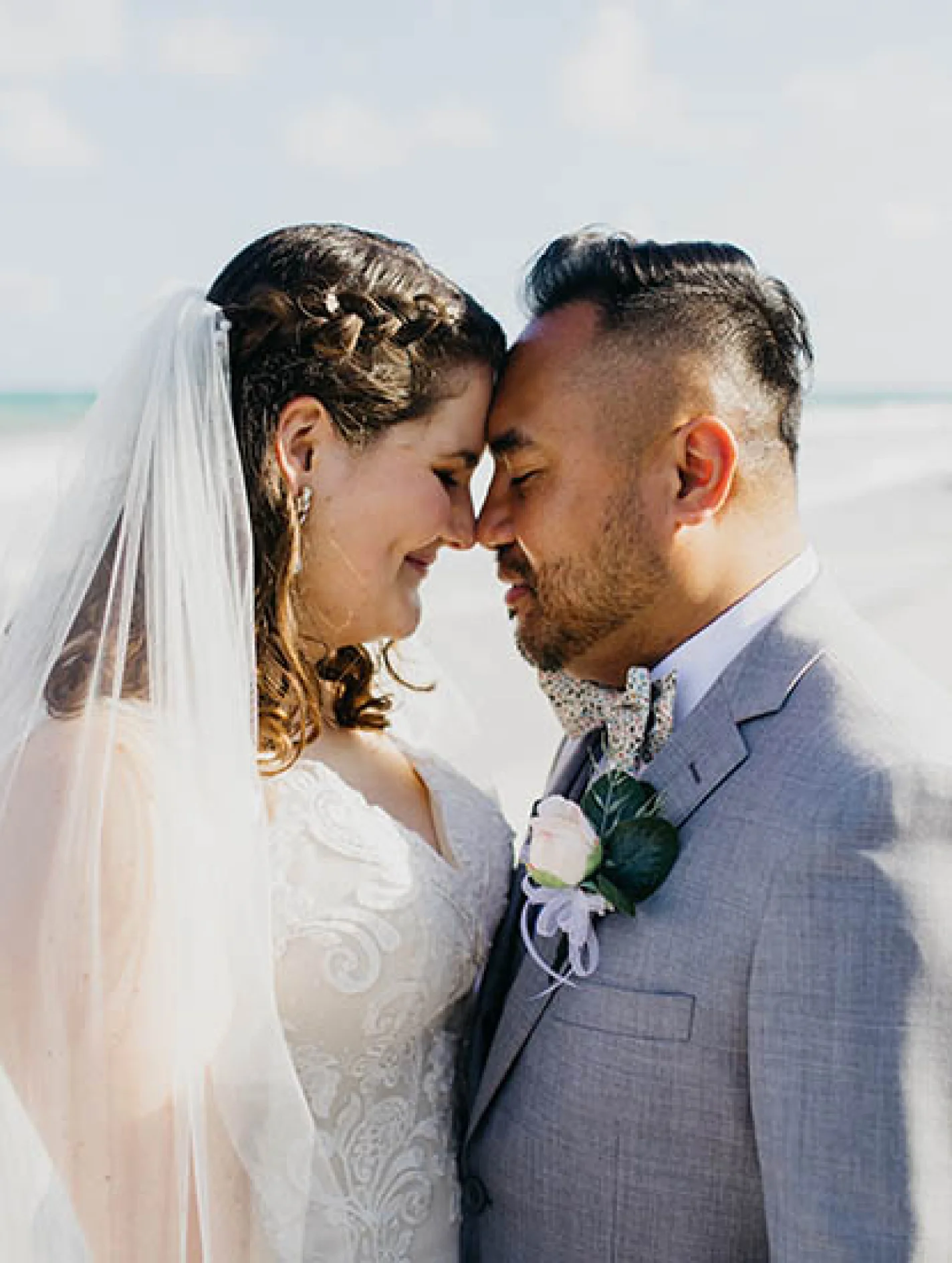 bride and groom looking at each other on the beach