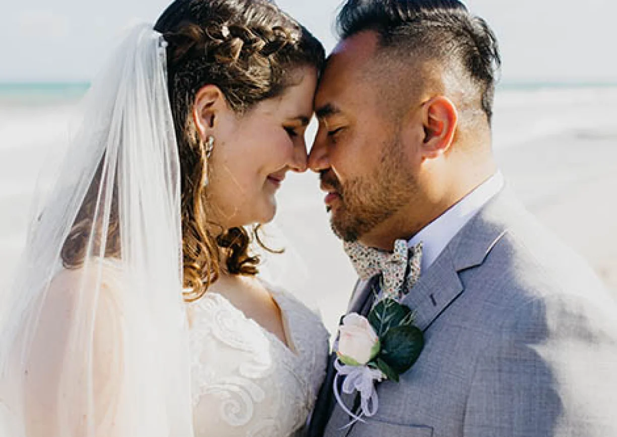 bride and groom looking at each other on the beach