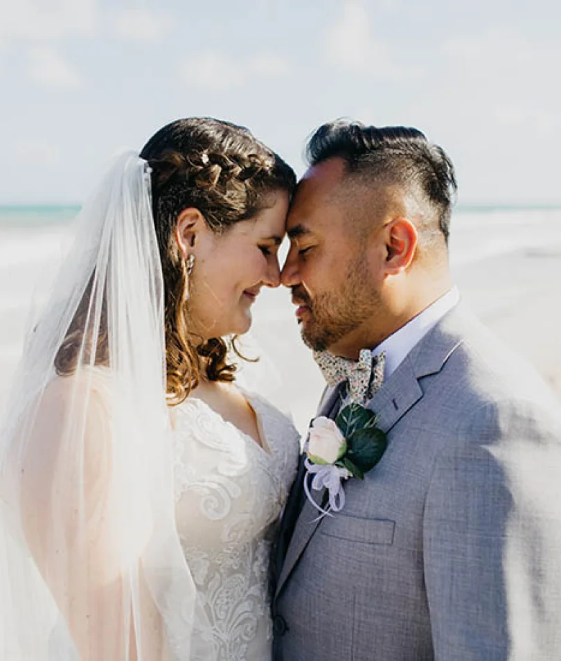 bride and groom looking at each other on the beach
