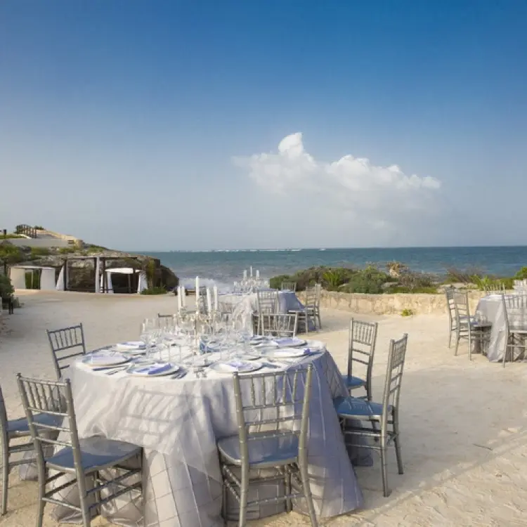 Outdoor wedding reception with round tables on the sand at Kore Tulum