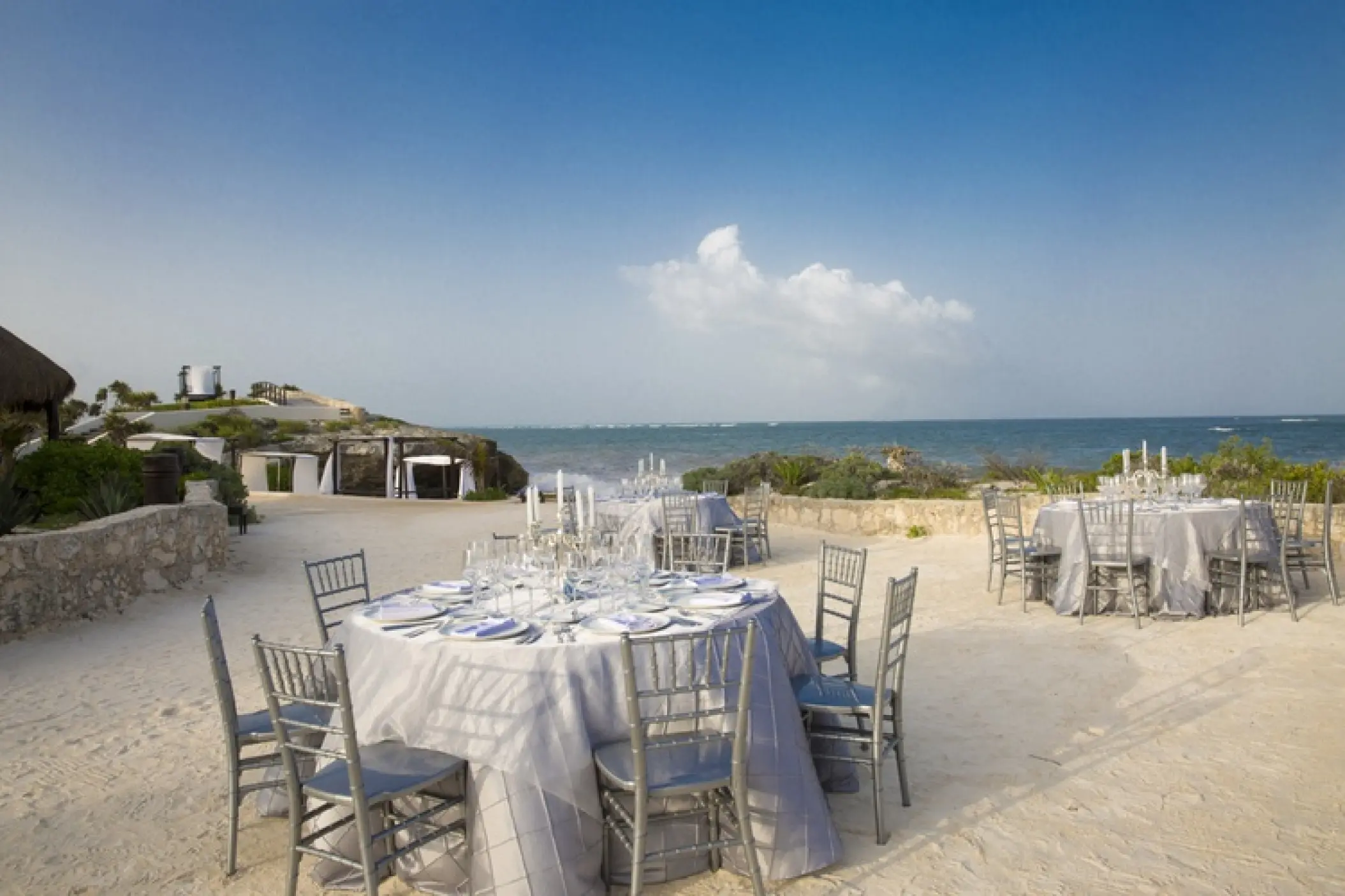 Outdoor wedding reception with round tables on the sand at Kore Tulum