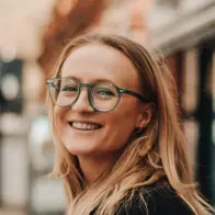 Paradise Weddings planner smiling and wearing green glasses