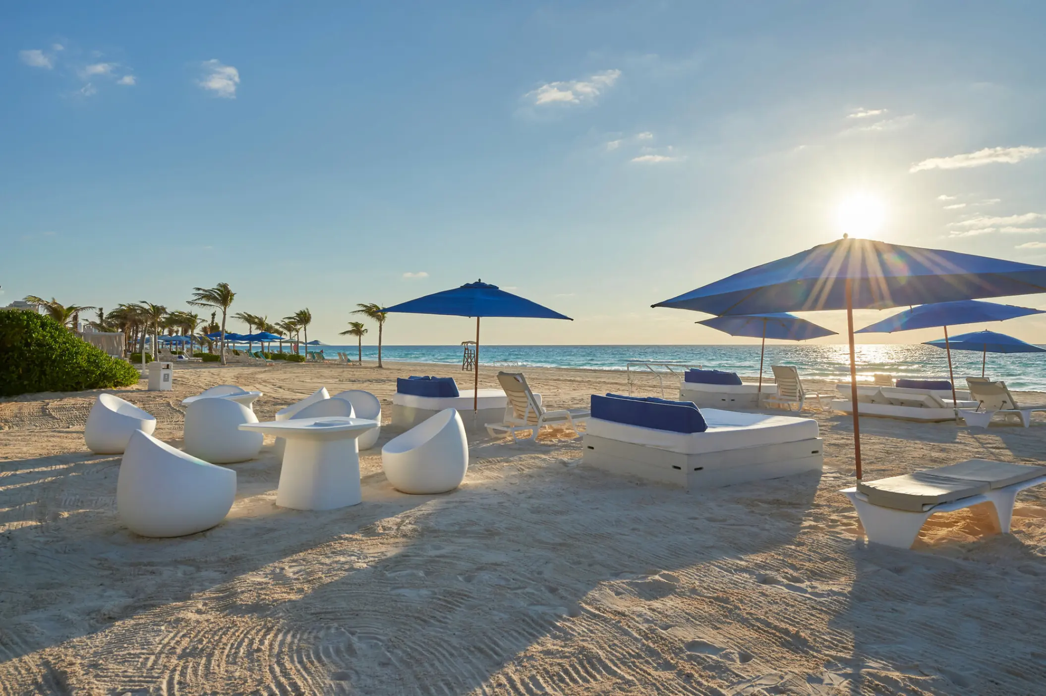 Live Aqua Beach Resort lounge area on the sand at sunset, Cancun