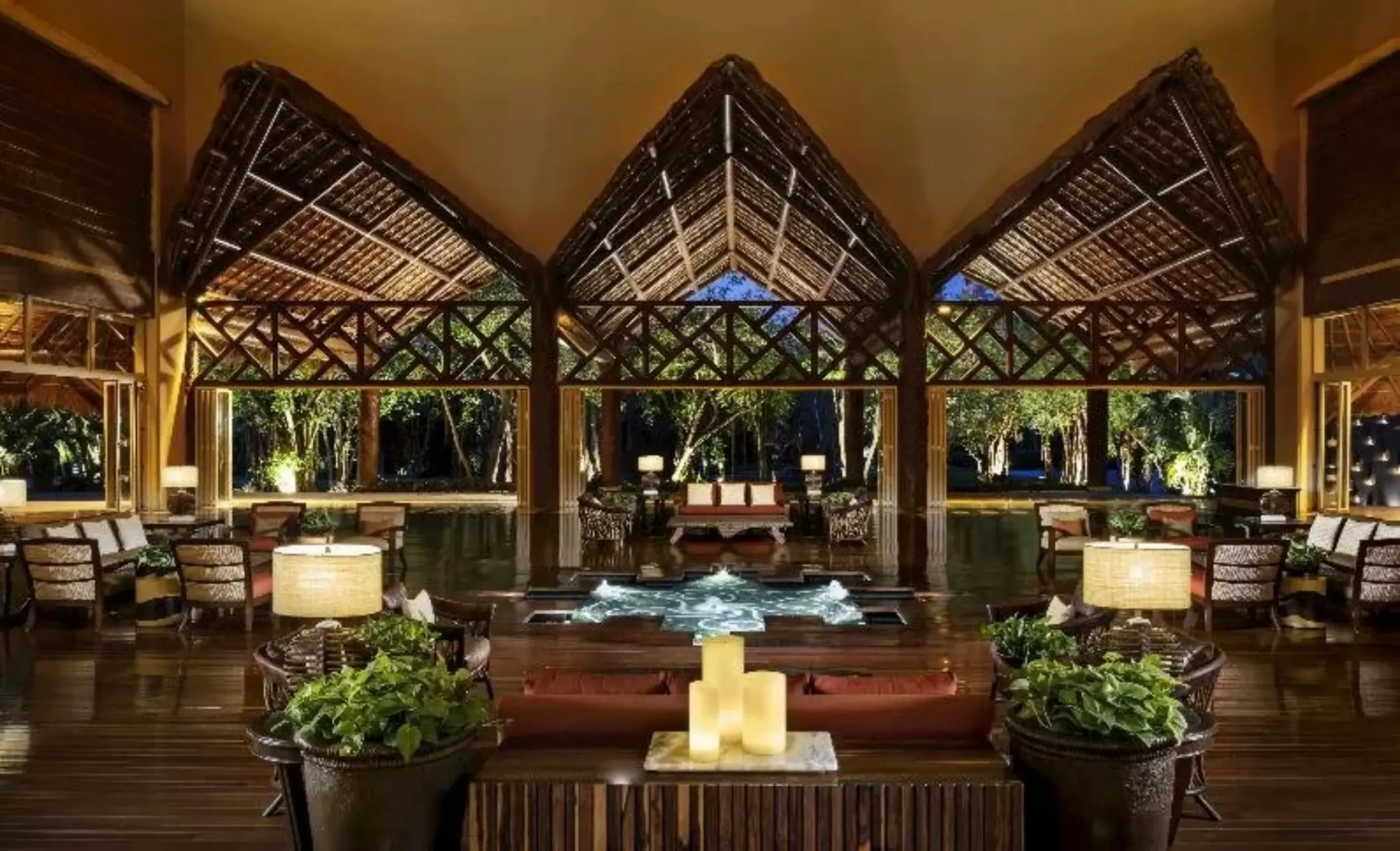 Open-air lobby with high thatched ceilings and water feature at Grand Velas Riviera Maya