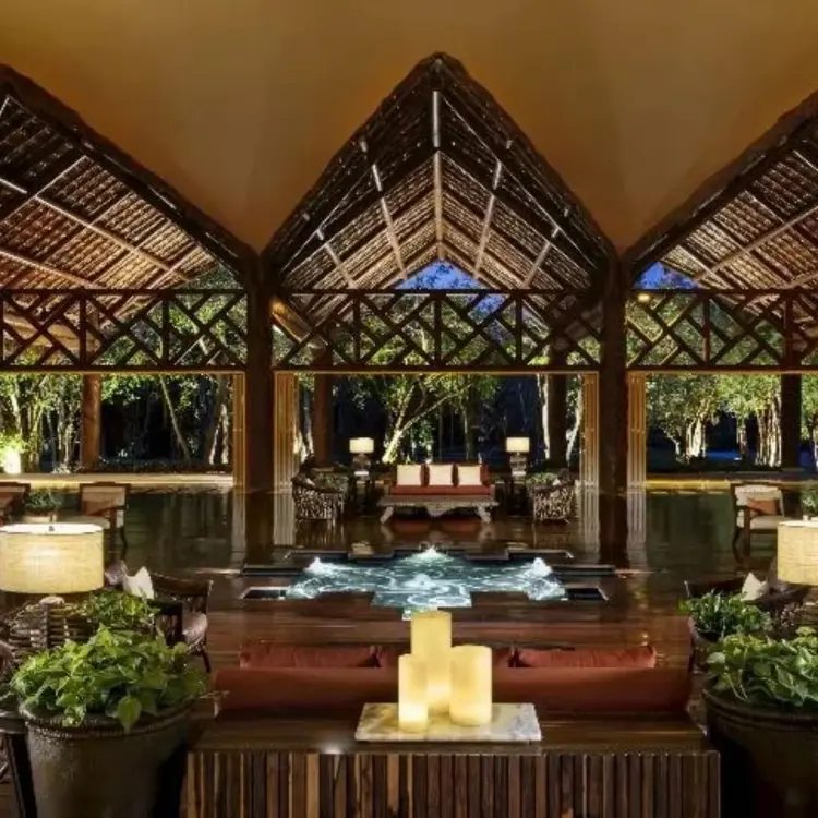 Open-air lobby with high thatched ceilings and water feature at Grand Velas Riviera Maya