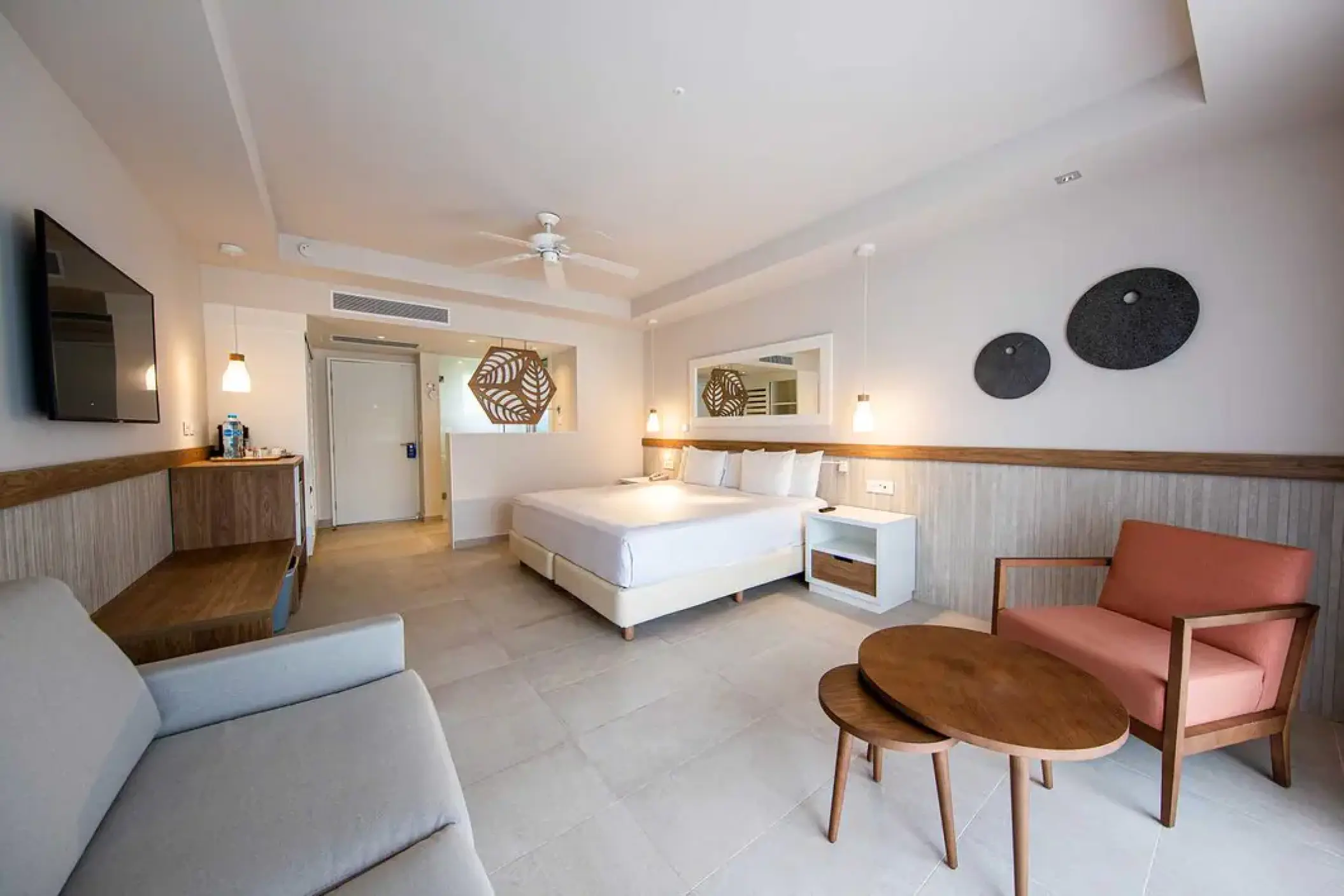 Modern suite with a king bed and seating area at Excellence El Carmen, Punta Cana