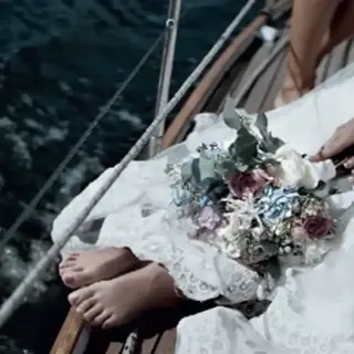 Bride sitting on a boat deck with her bouquet for a wedding ceremony at Paradisus Cancun