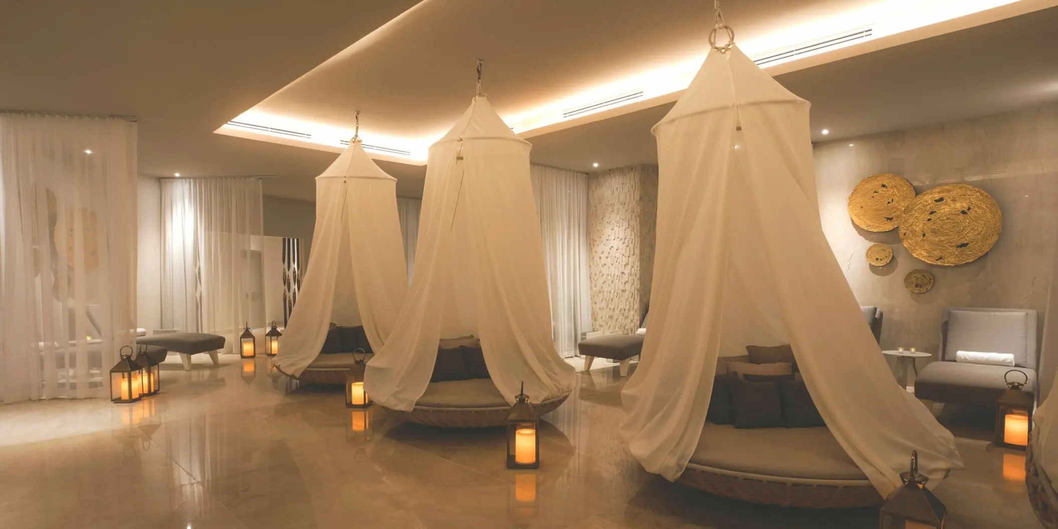 Spa relaxation lounge with canopy daybeds and lanterns at Le Blanc Spa Resort, Cabo San Lucas