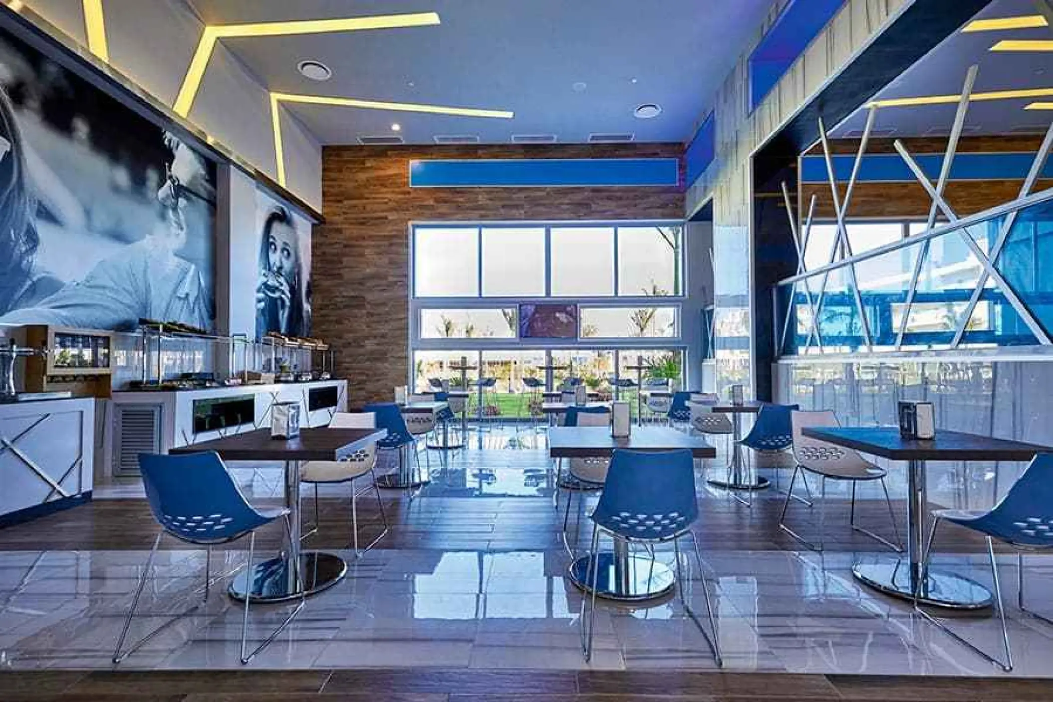Modern lounge with blue chairs and wood-paneled walls at Riu Palace Costa Mujeres, Cancun