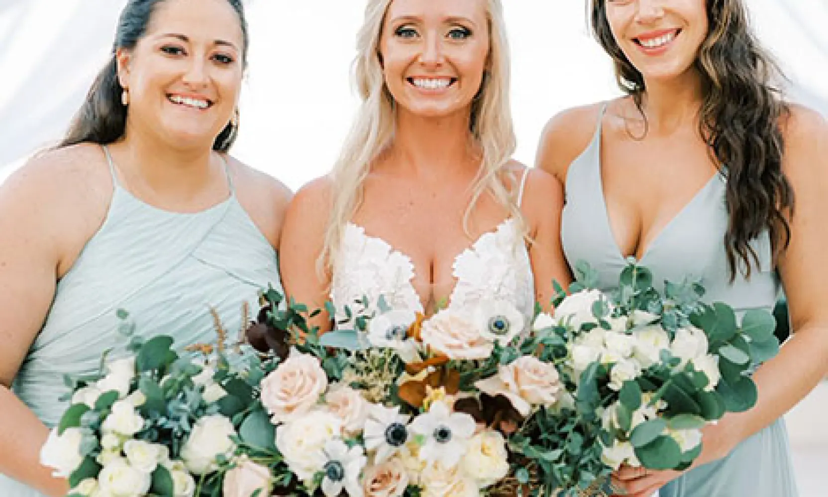 Lynsie and her bridesmaids holding floral bouquets during her wedding in Cancun