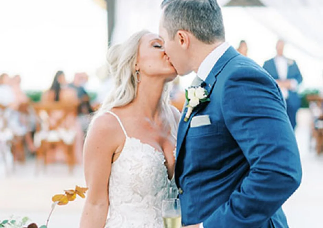 Bride kissing groom in front of the isle
