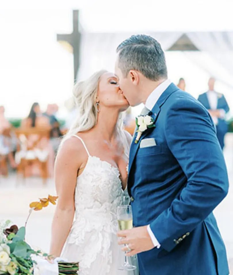 Lynsie and Chris sharing a first kiss during their wedding ceremony