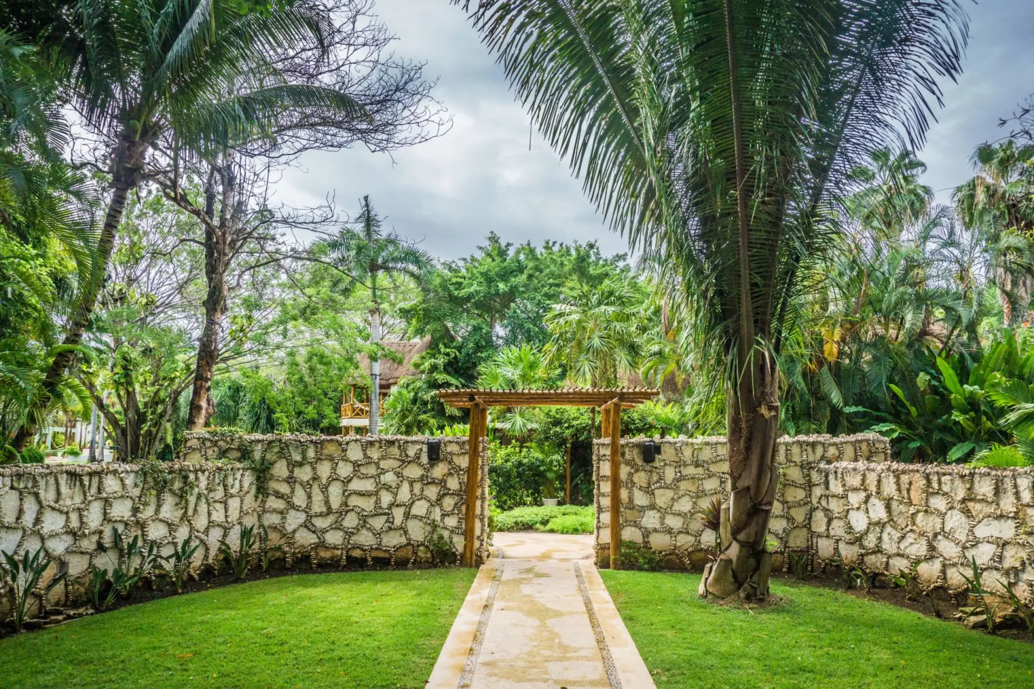 Stone-walled garden entrance to a wedding ceremony venue at Mahekal Beach Resort, Playa Del Carmen