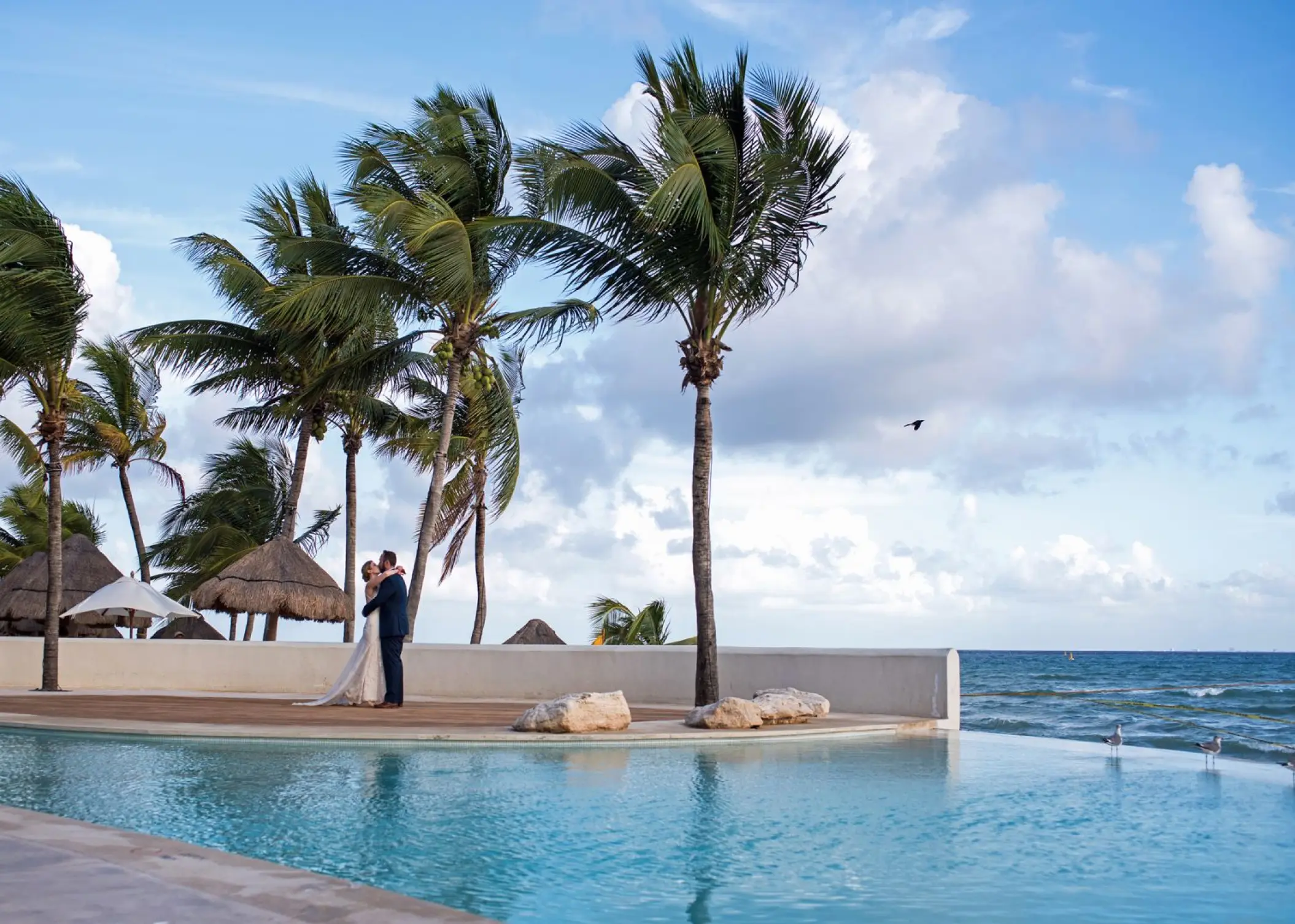 Bride and groom by the infinity pool at Mahekal Beach Resort, Playa Del Carmen