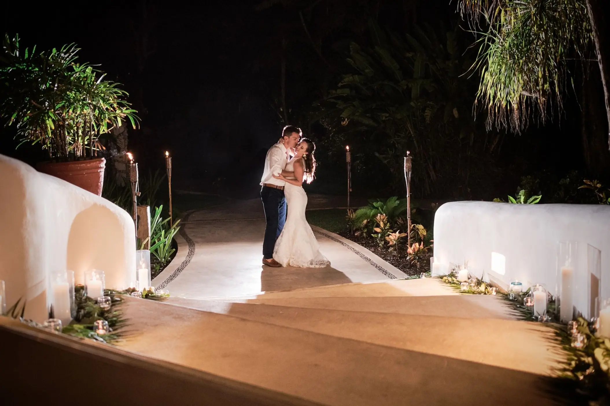 Bride and groom kissing at a night reception at Mahekal Beach Resort, Playa Del Carmen