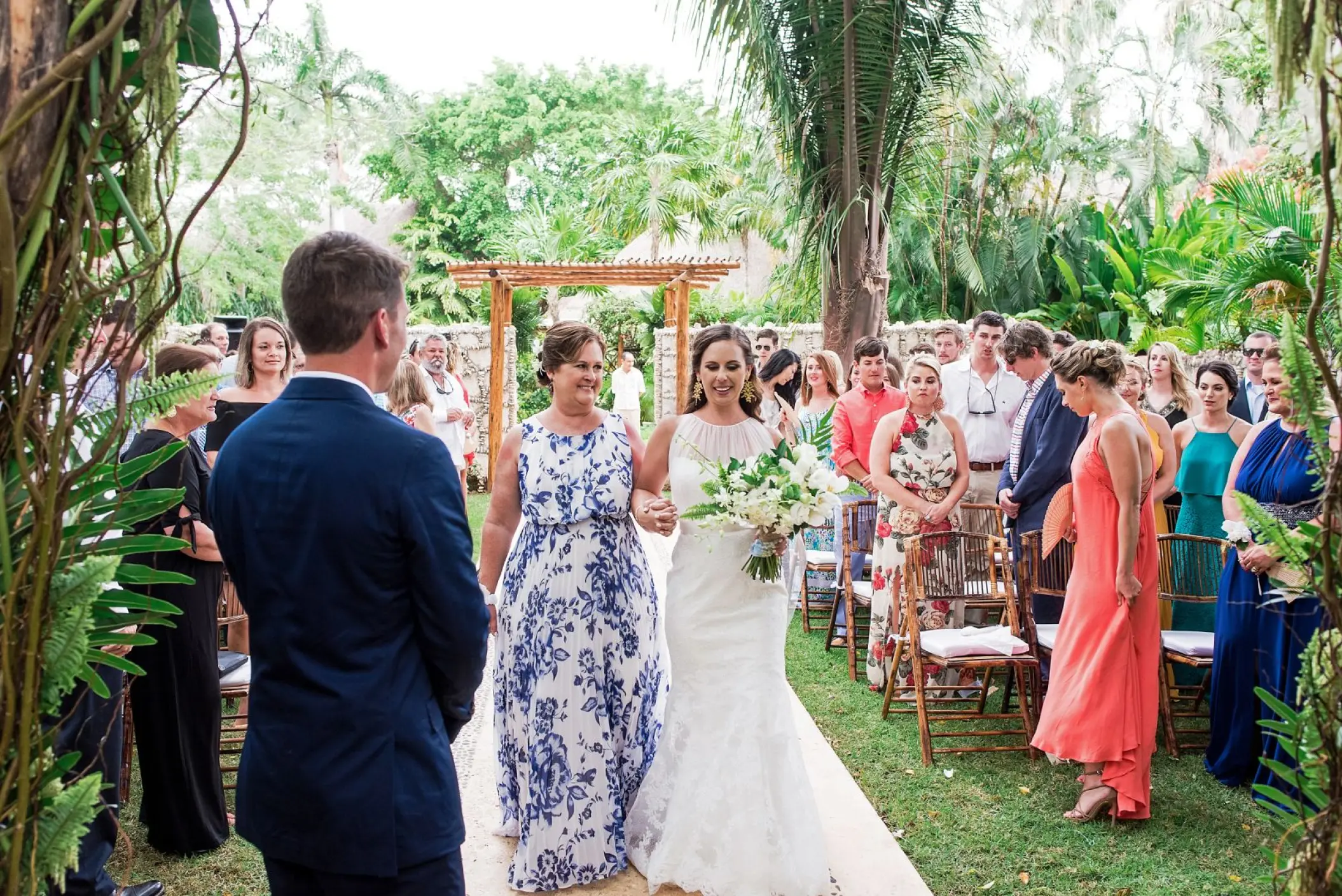 Bride walking down the aisle at a garden wedding ceremony in Mahekal Beach Resort, Playa Del Carmen