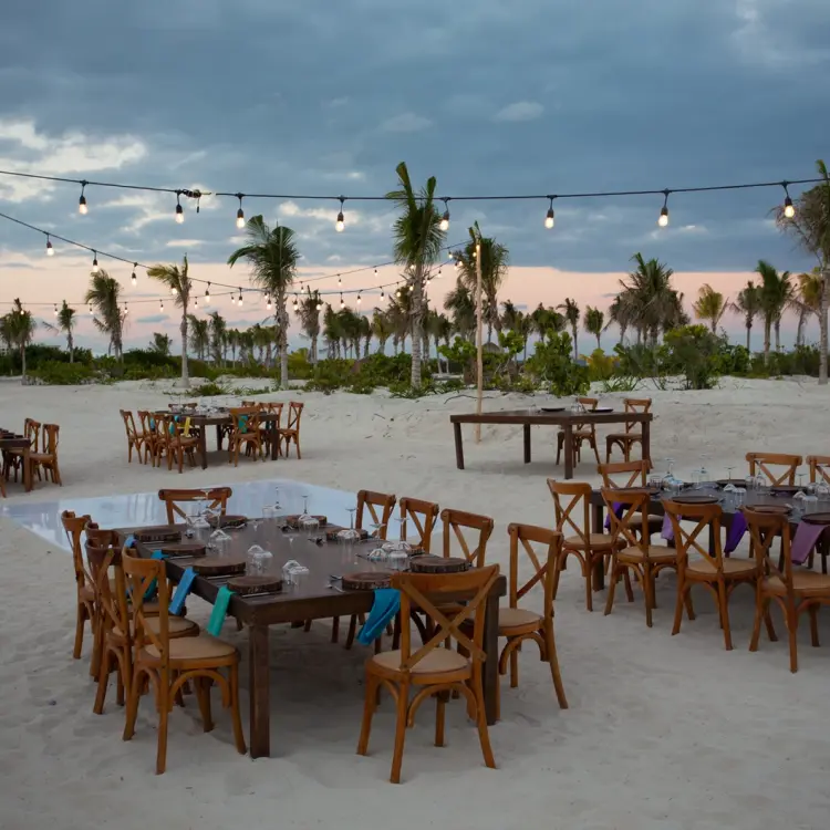 Beach wedding reception under string lights at Majestic Elegance Costa Mujeres, Cancun