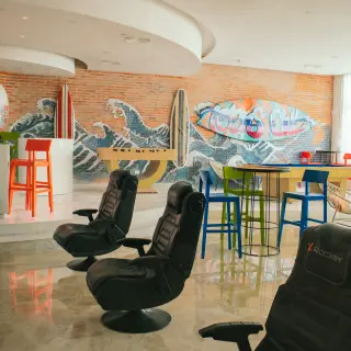 Teens club with gaming chairs and surf murals at Majestic Elegance Costa Mujeres, Cancun