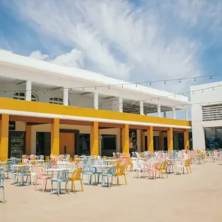 Outdoor theater seating area with colorful chairs and tables at Majestic Elegance Costa Mujeres, Cancun