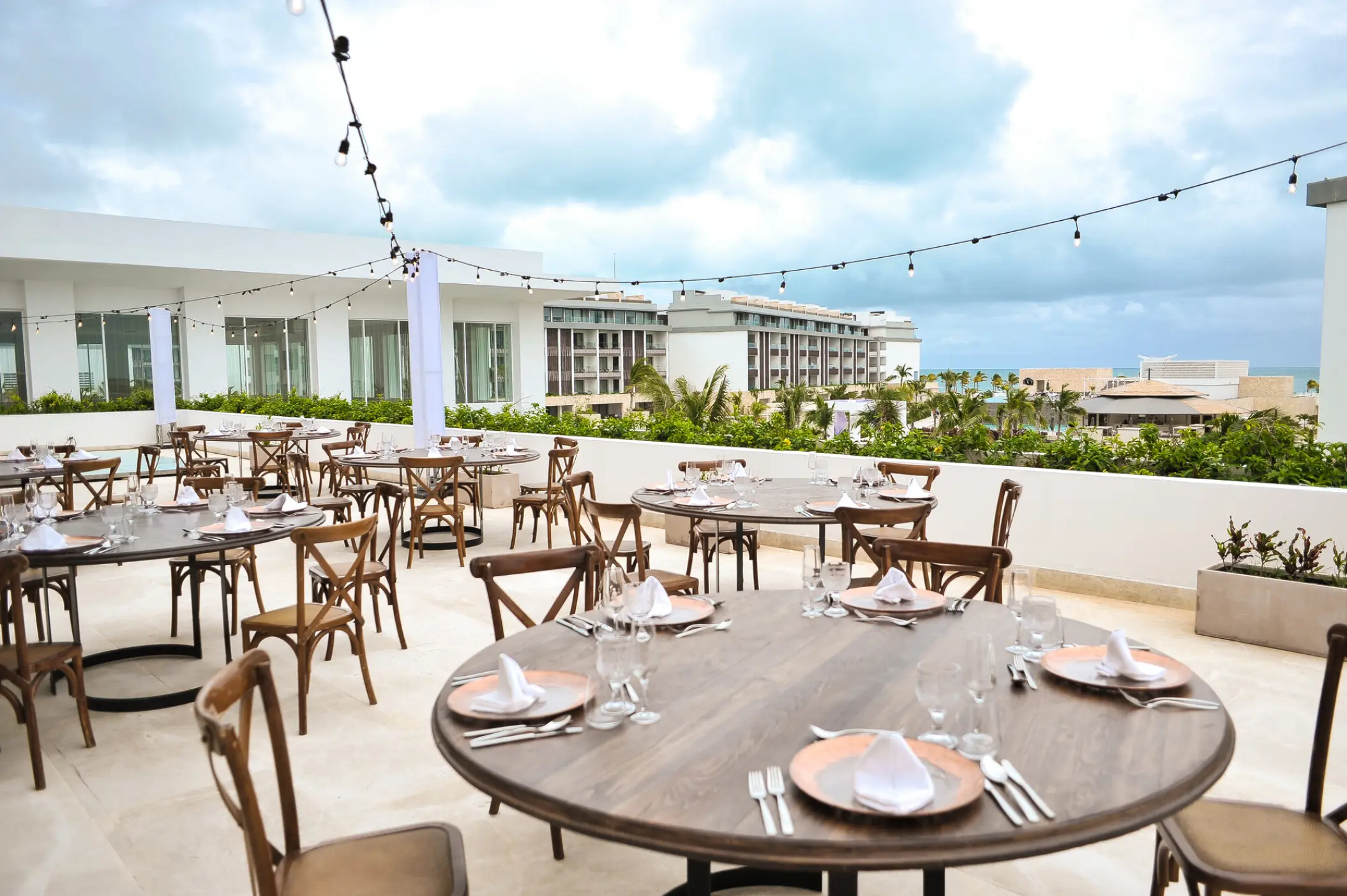 Outdoor wedding reception setup with string lights on the terrace at Majestic Elegance Costa Mujeres, Cancun