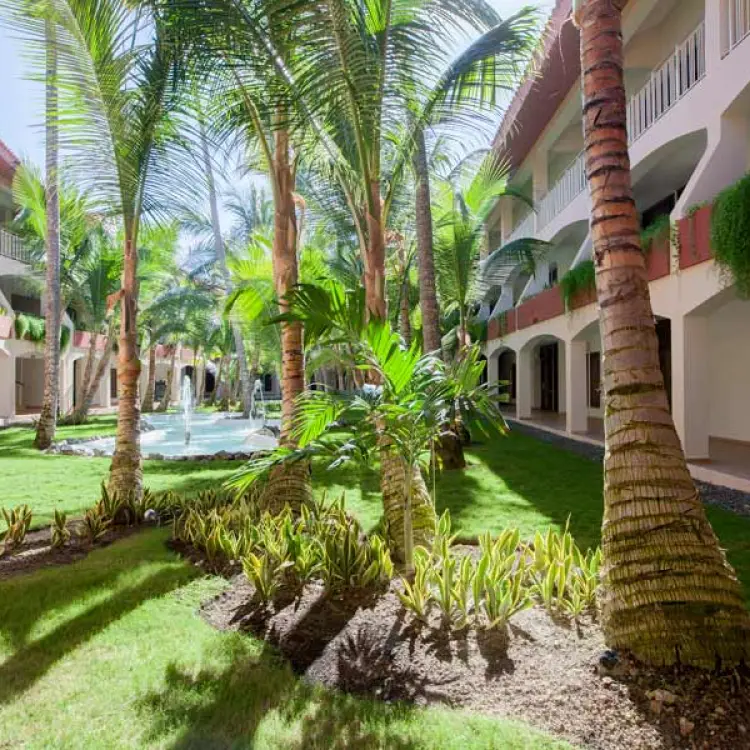Lush tropical gardens and fountain between guest room buildings at Majestic Elegance Punta Cana, Punta Cana