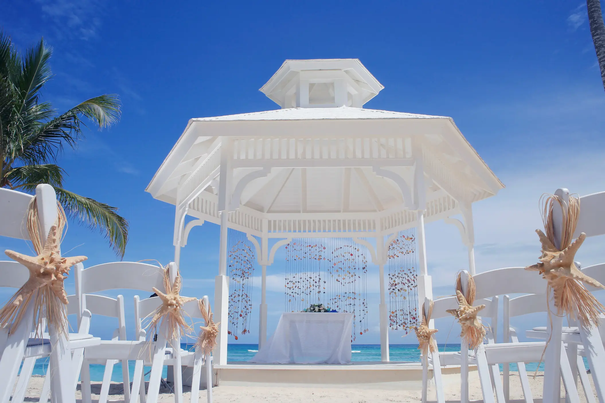 White beach gazebo ceremony setup with starfish decor at Majestic Elegance, Punta Cana