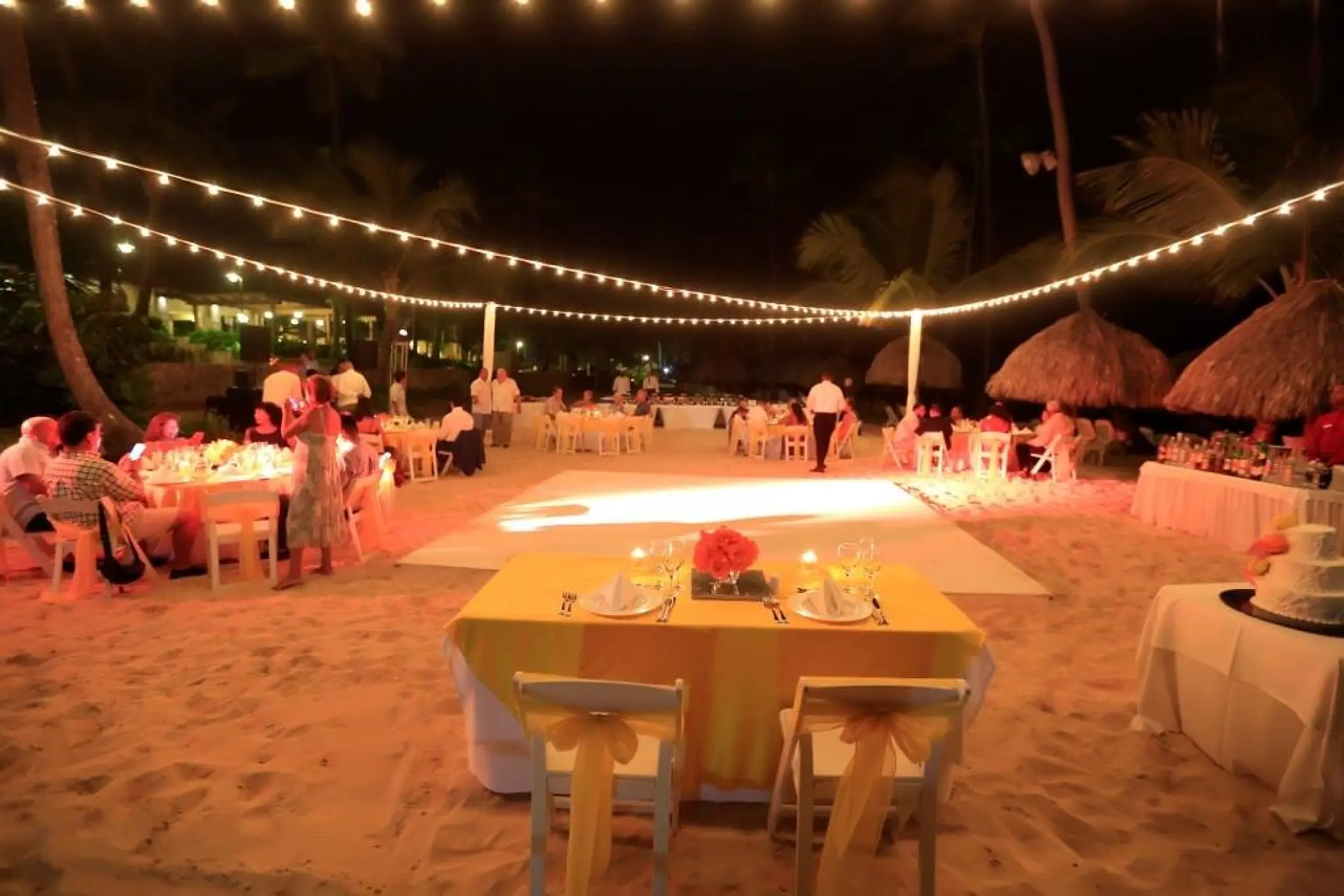 Nighttime beach wedding reception under string lights at Majestic Elegance Punta Cana