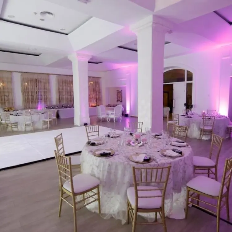 Indoor ballroom wedding reception with pink lighting and dance floor at Majestic Elegance Punta Cana