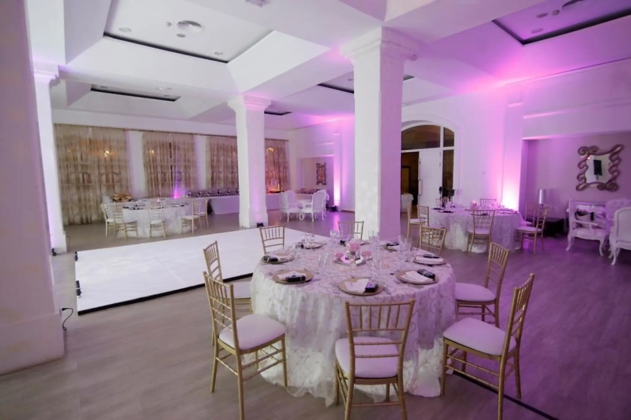 Indoor ballroom wedding reception with pink lighting and dance floor at Majestic Elegance Punta Cana