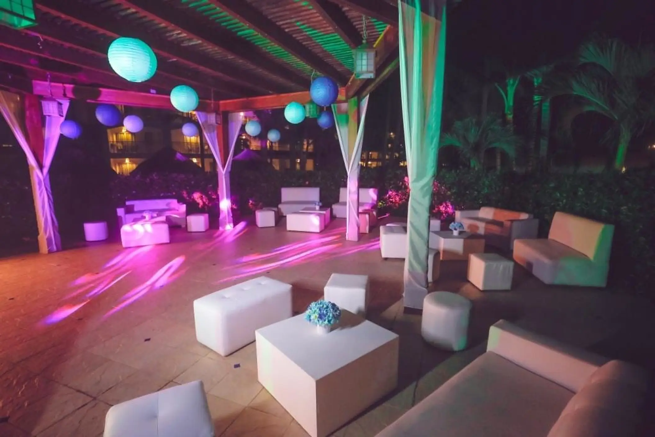 Evening wedding reception lounge with colorful lanterns and white seating at Majestic Elegance, Punta Cana