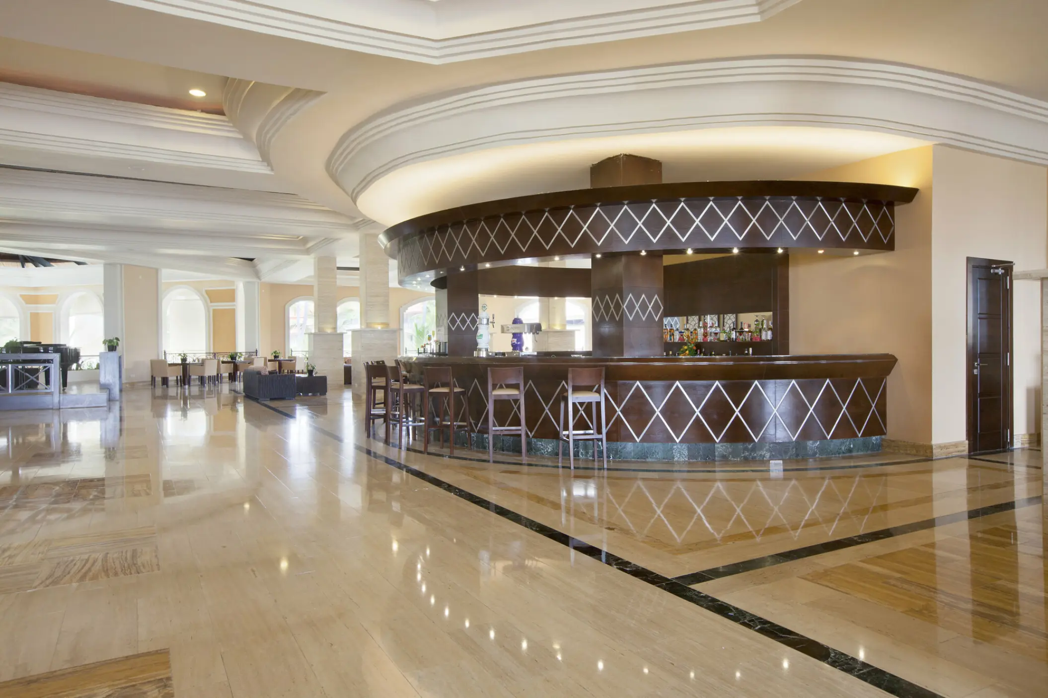The piano bar with dark wood and diamond detailing at Majestic Elegance Punta Cana