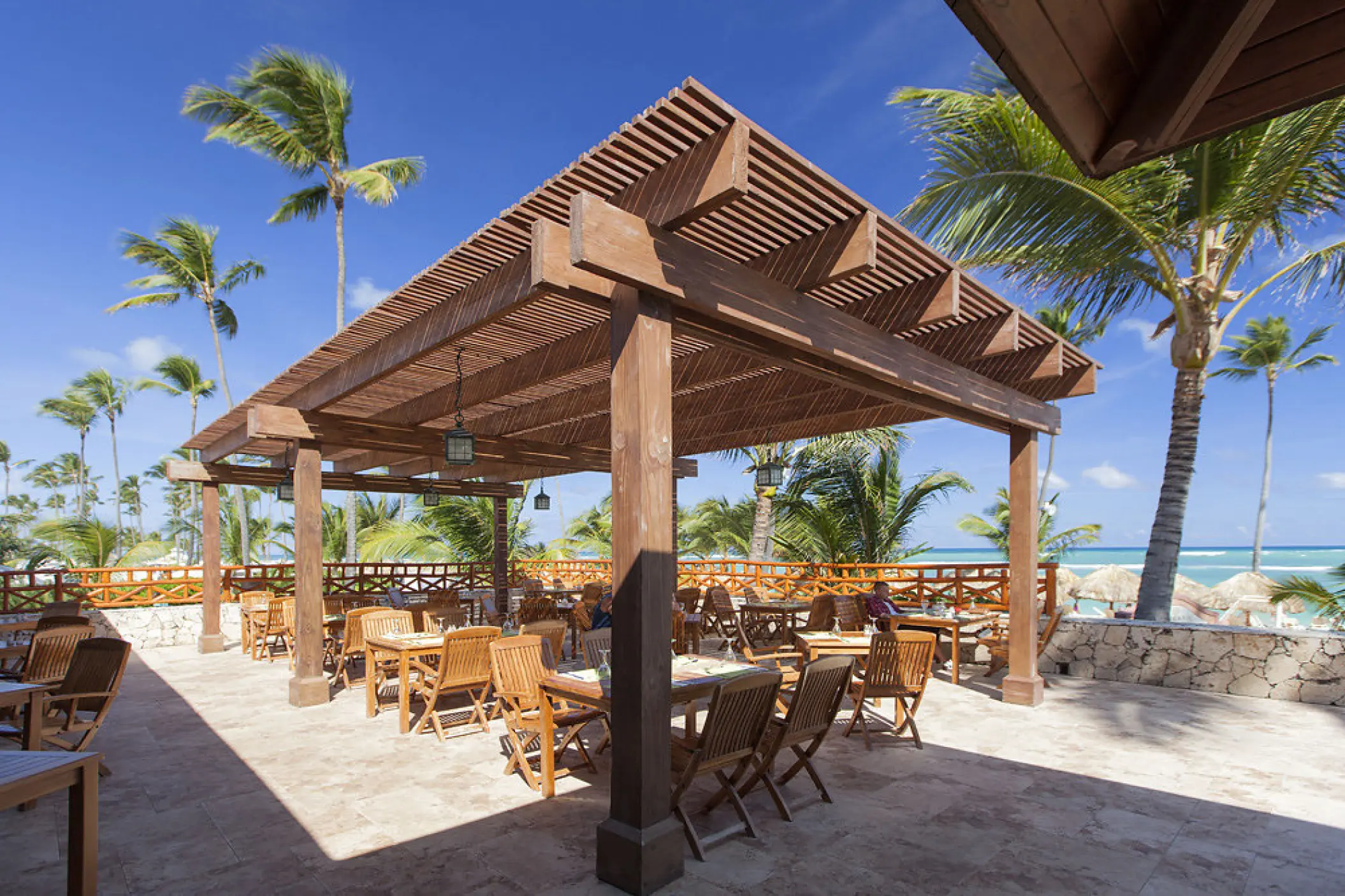 Wooden pergola over an outdoor dining terrace at Majestic Elegance, Punta Cana