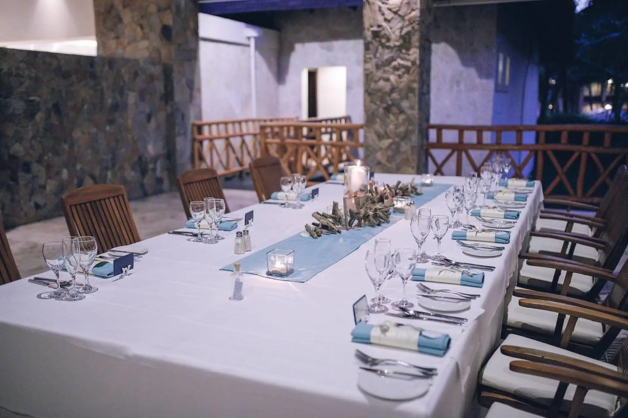 Wedding reception table setup with blue runner and wooden chairs at Majestic Elegance Punta Cana