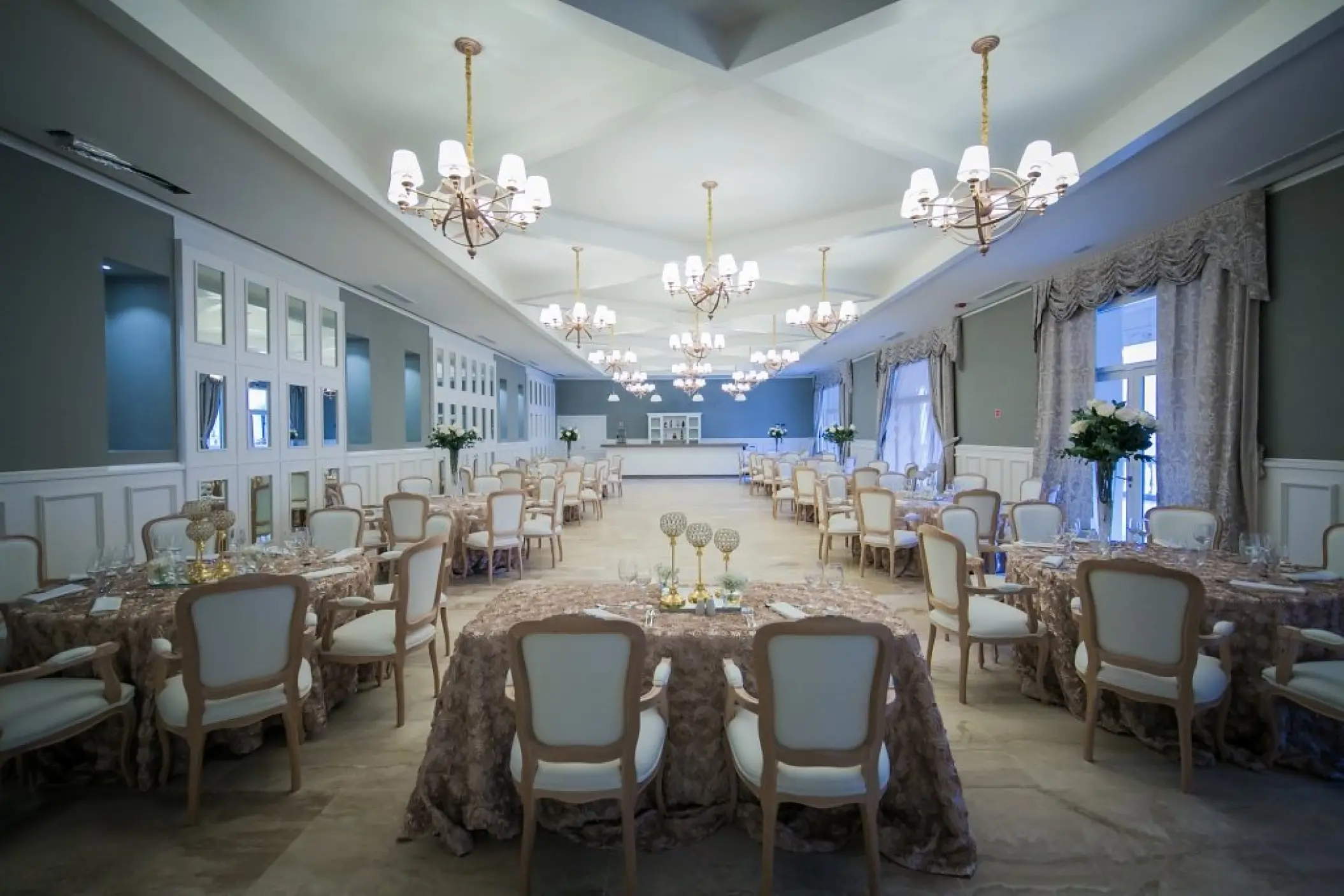 Indoor wedding reception ballroom with chandeliers and set tables at Majestic Mirage, Punta Cana