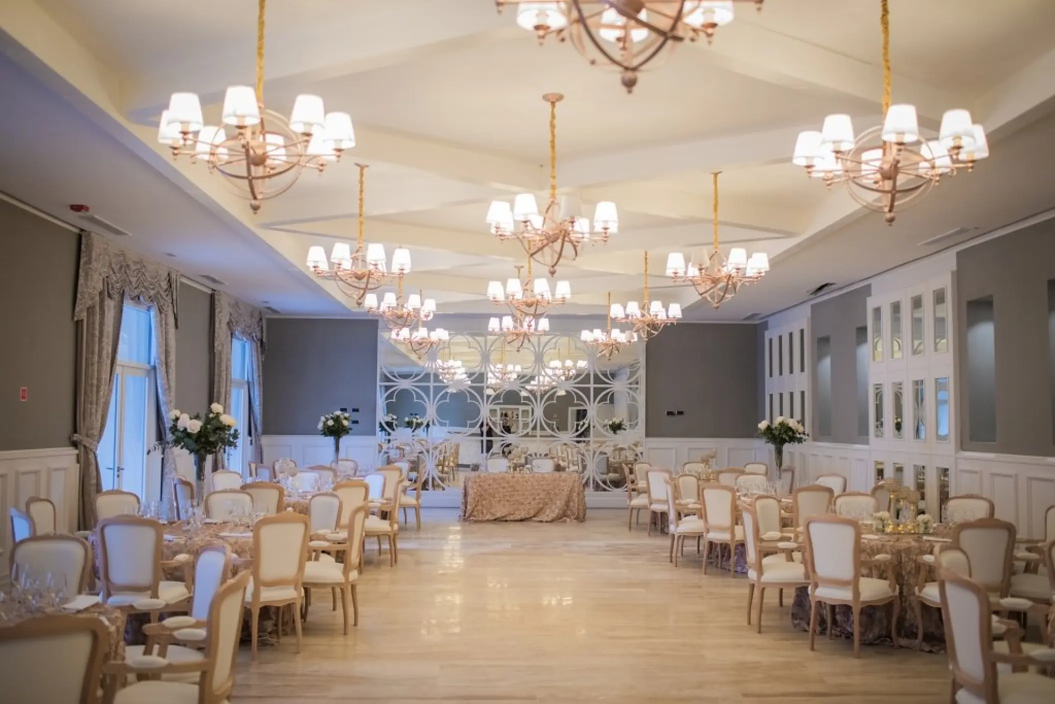 Indoor ballroom wedding reception with chandeliers and round tables at Majestic Mirage, Punta Cana