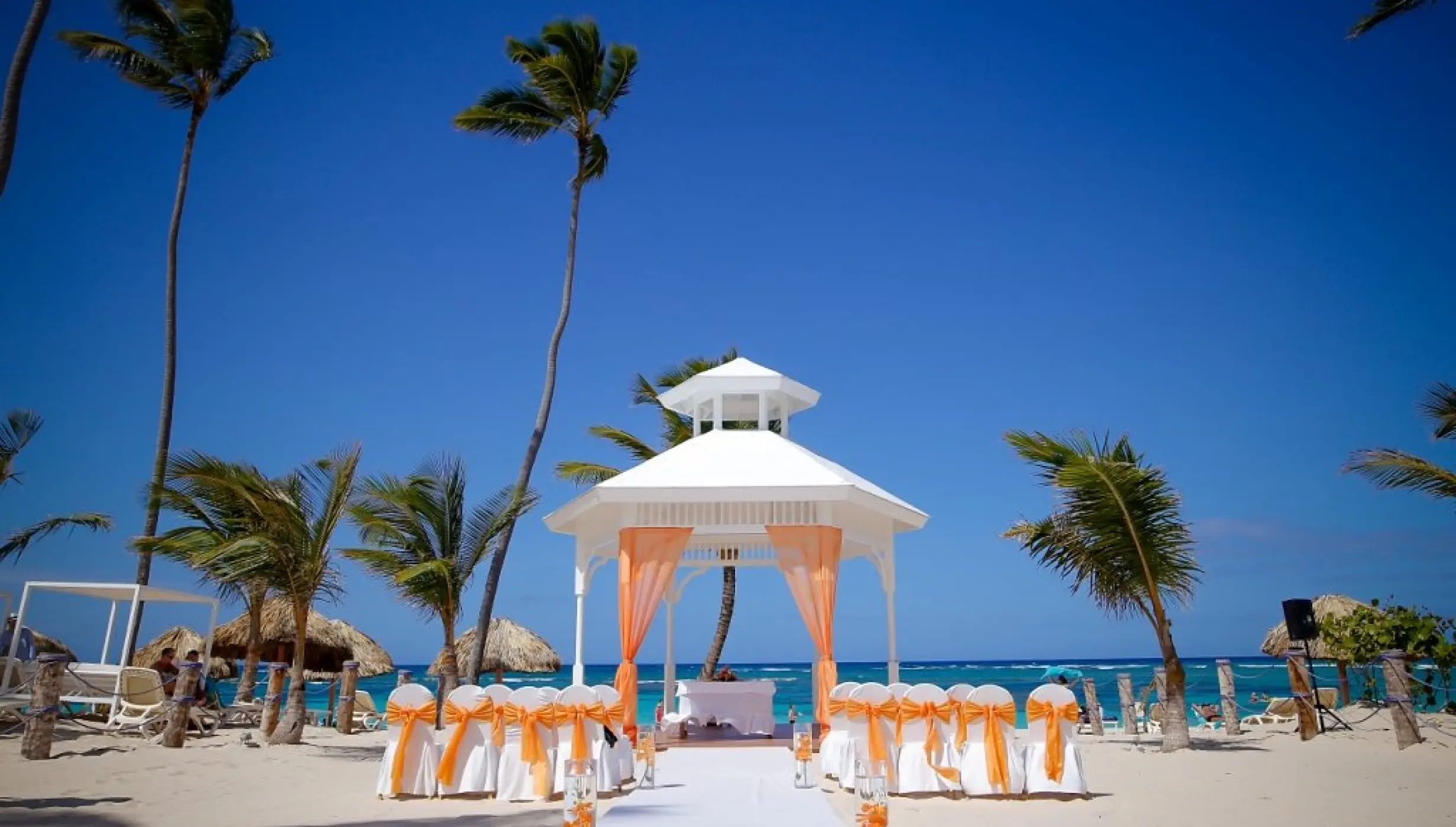 White beach gazebo wedding ceremony with orange drapes at Majestic Mirage, Punta Cana